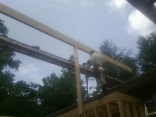 Carpenter setting a ridge beam over a new addition frame — Ice Dam Removal by Roofing Brothers in Haven