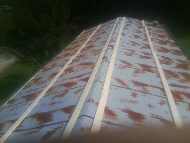 Rusted metal roof panels with new wood purlins before replacement — Storm Damage Roof Repair in Haven by Roofing Brothers