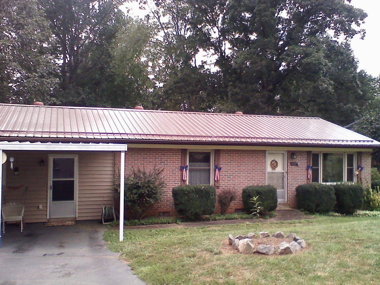 Bronze metal roof and carport on a brick ranch home — Roof Repair work by our crew in Haven