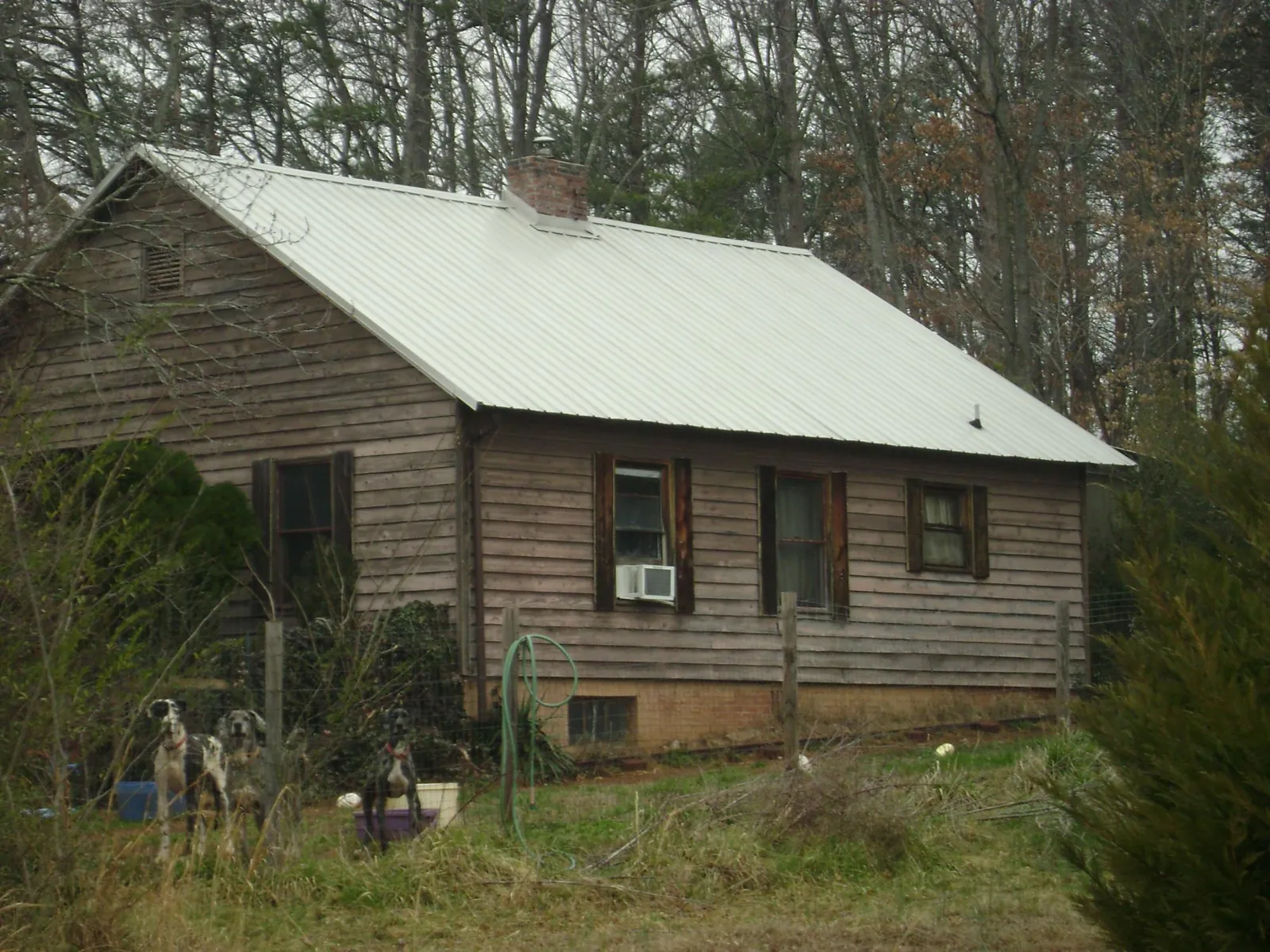White metal roof on an old wood sided farmhouse, from a Metal Roof Installation job in Haven